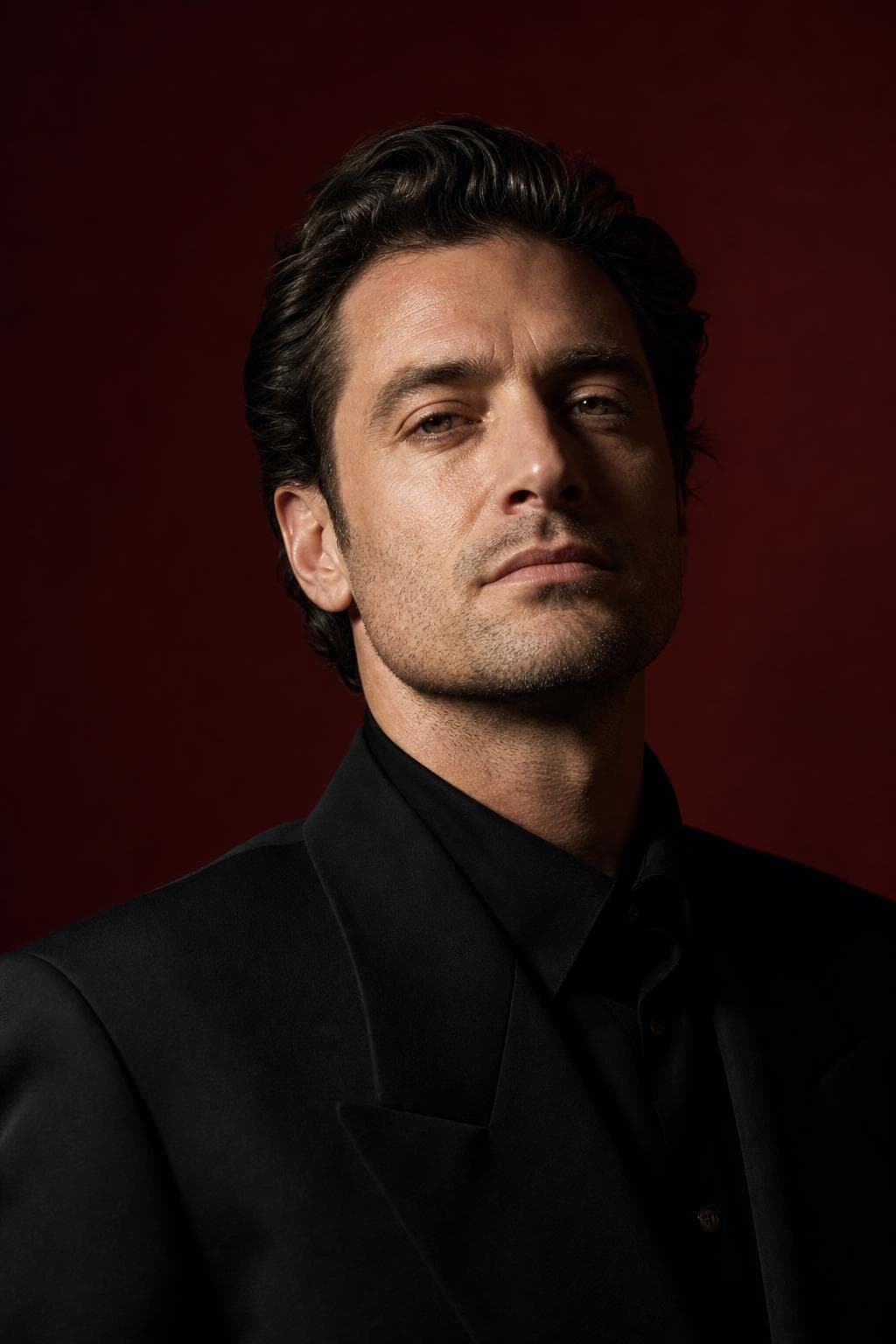 AI profile picture in Public Bio style — man in a structured black jacket, oxblood backdrop, one dramatic light