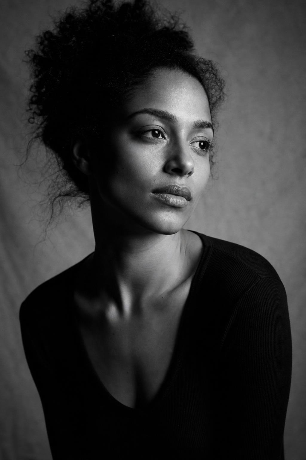 AI-generated black-and-white editorial portrait — strong side lighting, film grain